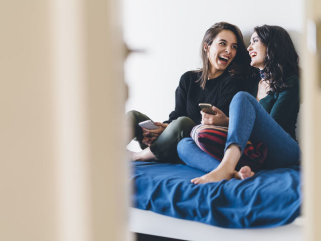 Two young women friends sharing happy time together
